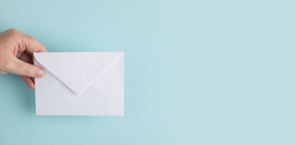 Eine Hand, die ein Kuvert h&auml;lt