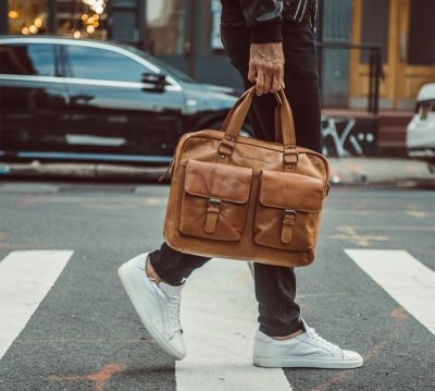 Mann mit Leder-Aktentasche in der Hand